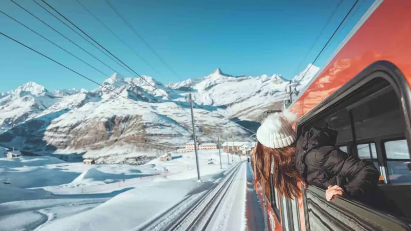 Passenger train traveling through snowy mountains in winter