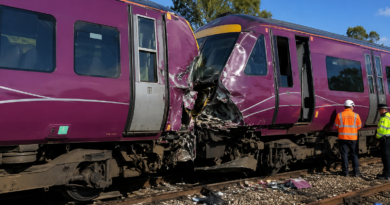 Damaged passenger train after a collision as emergency crews inspect the scene.