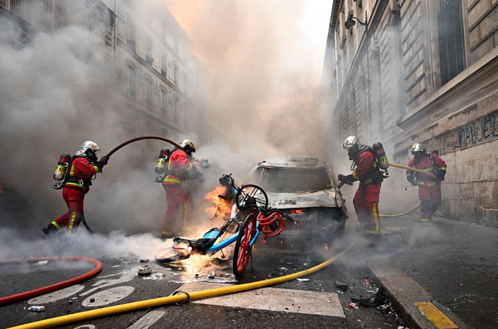 Firefighters respond to a burning vehicle in Paris during violent disturbances on 17 October 2026. Firefighters respond to a burning vehicle