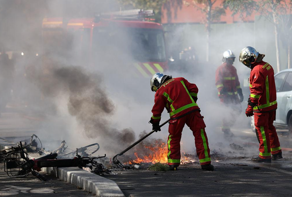 Emergency crews extinguish burning bicycles on Boulevard Voltaire in Paris during the unrest. Emergency crews extinguish burning bicycles on Boulevard Voltaire in Paris during the unrest.